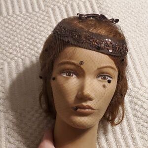 1960s brown satin ring hat with netting and feathers.